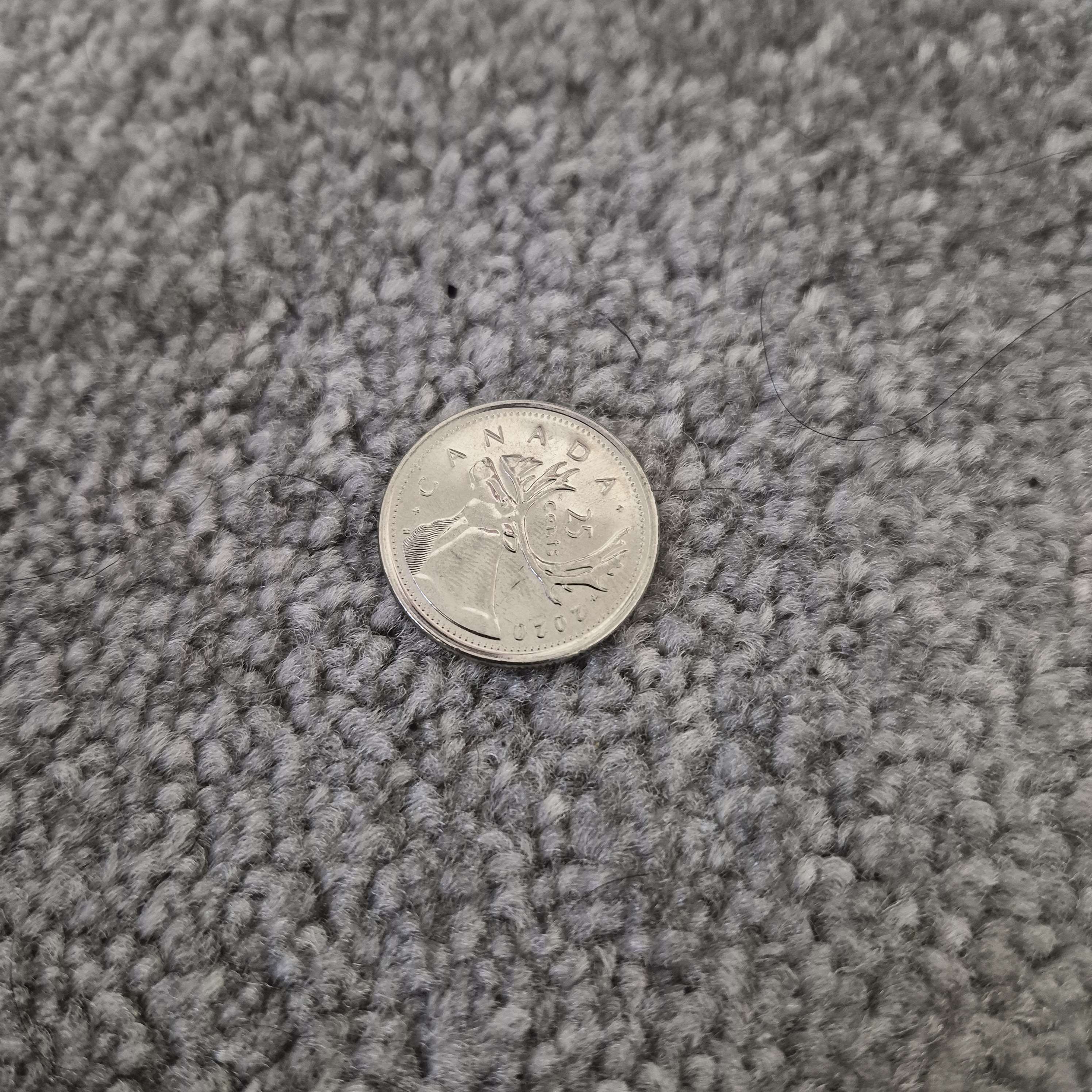 A Canadian 25-cent coin is used as a conductive touch input, allowing interaction through the Makey Makey.
