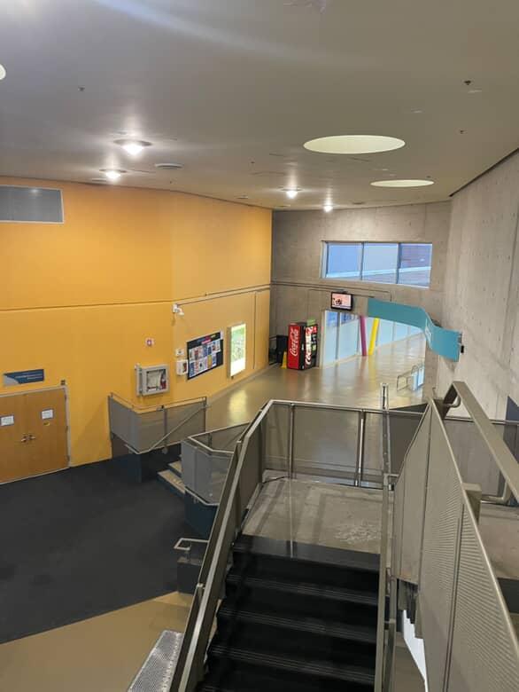 Space 1 – Stairwell and Lounge Area
This is the main staircase I take every day to all my Interaction Design classes.
It’s always packed with students going up and down between classes.
Sometimes people stop here to talk or wait for their friends.
Style: Kind of industrial but with a bright, welcoming feel.
What I see:

Grey concrete walls
Metal railings
A bright yellow wall that adds energy
Round ceiling lights that make it feel open and clean
Overall vibe: Feels bright, simple, and functional made for movement but doesn’t feel cold or dull.
<a href='https://www.youtube.com/embed/tgbNymZ7vqY' target='_blank'><p>Project Video Link</p></a>
